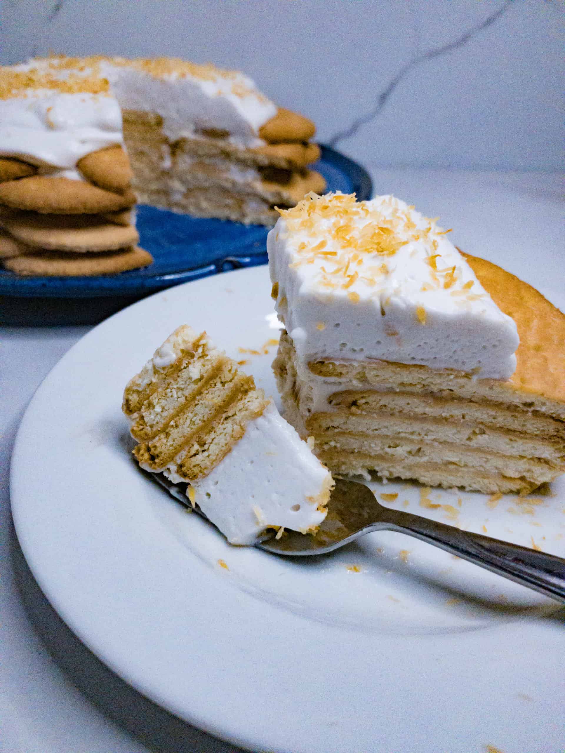 Slice of Hawaiian Coconut Icebox Cake with cake in the background