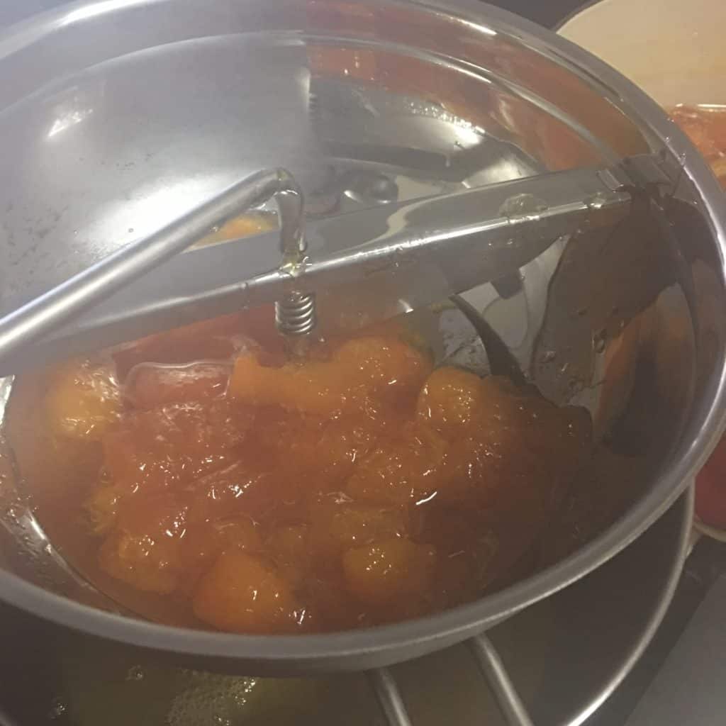 Making apricot jam - running the cooked fruit through a food mill