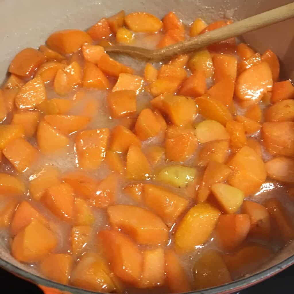 Making apricot jam - removing the foam while the fruit cooks