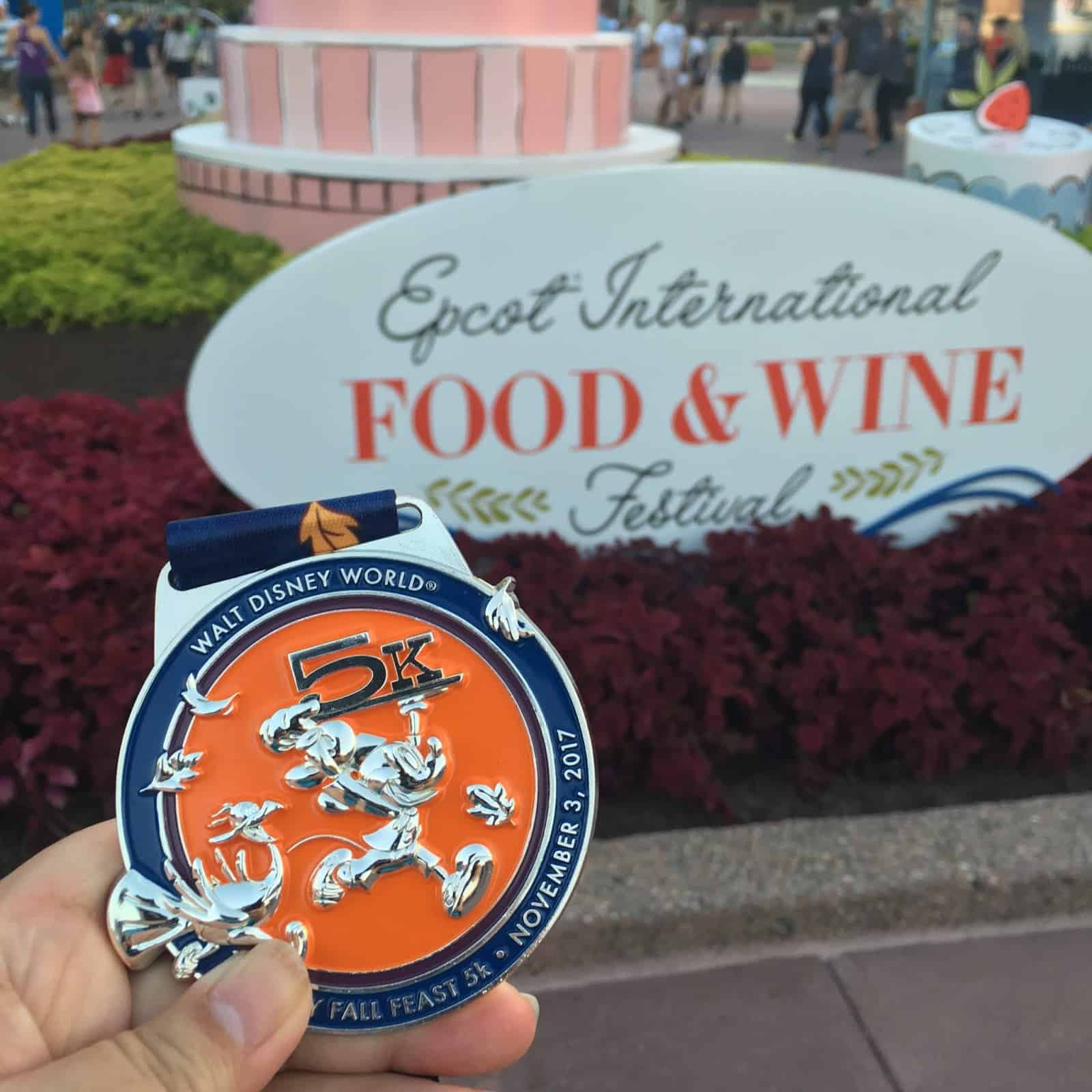 Fall Feast 5K medal in front of festival sign