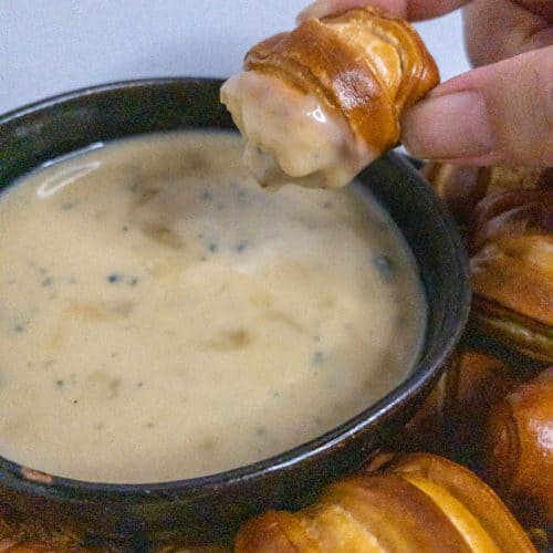 Pretzel bite dipped in blue cheese fondue